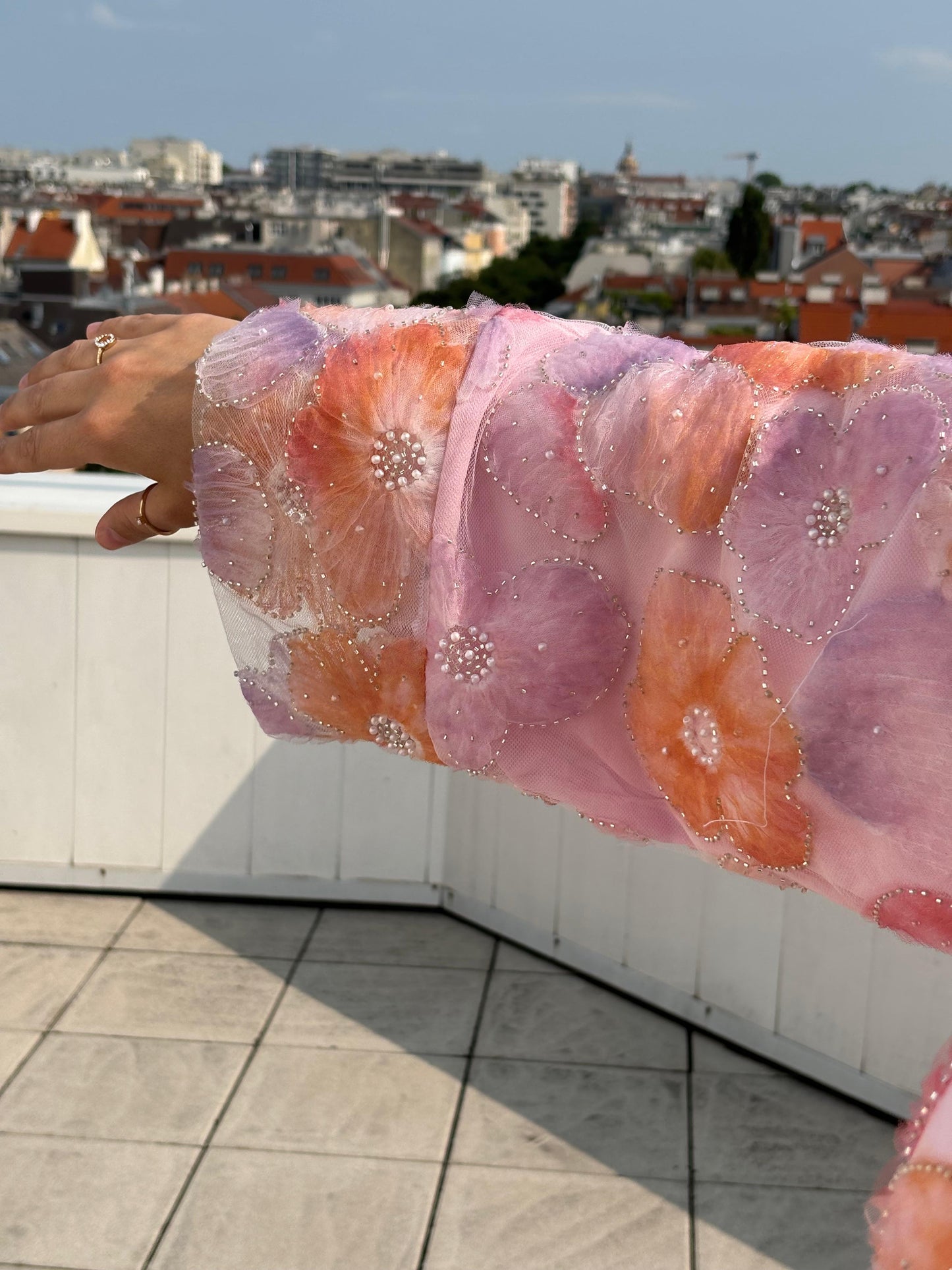 Detailaufnahme des Ärmels. Rosa und peachfarbene Abaya