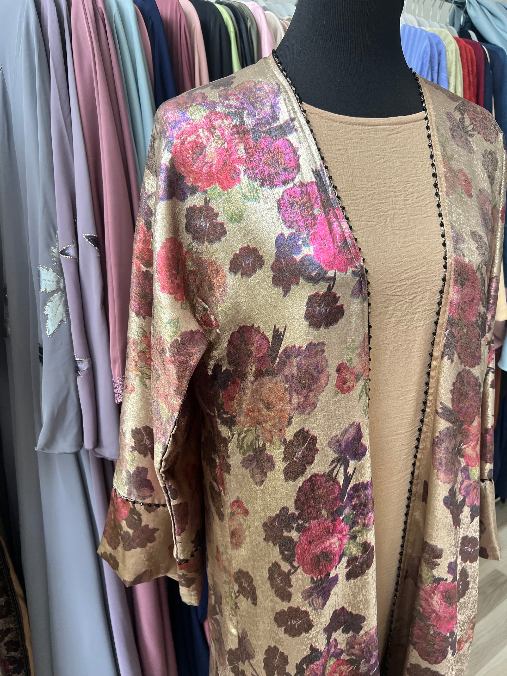 Detailaufnahme der Schulterpartie der Abaya Rania – die intensiven Rosatöne der floralen Muster kommen auf dem goldenen Jacquard besonders zur Geltung.“