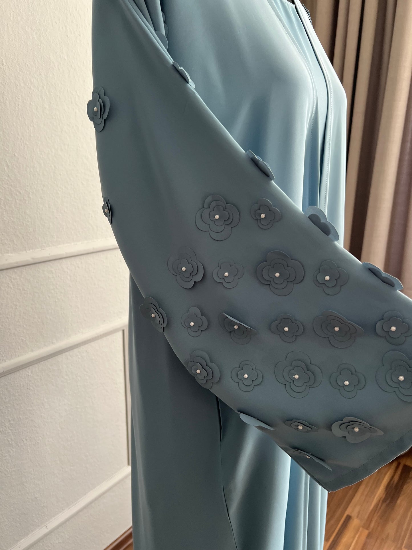 Close up hellblaue Abaya mit blumen an den ärmeln