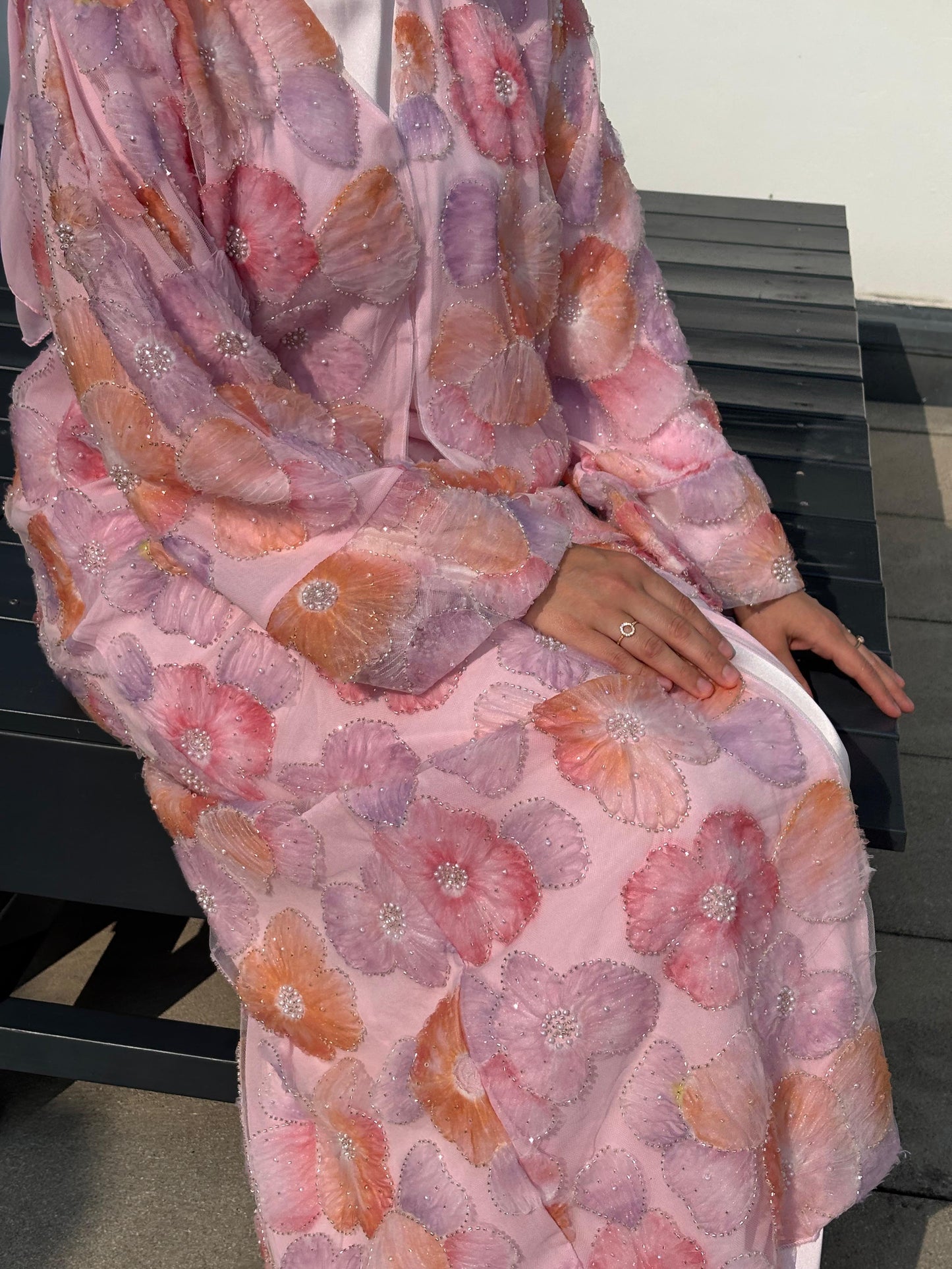 Sitzende Ansicht der Abaya Peachy Blossom – weicher Tüll und farbintensives Design