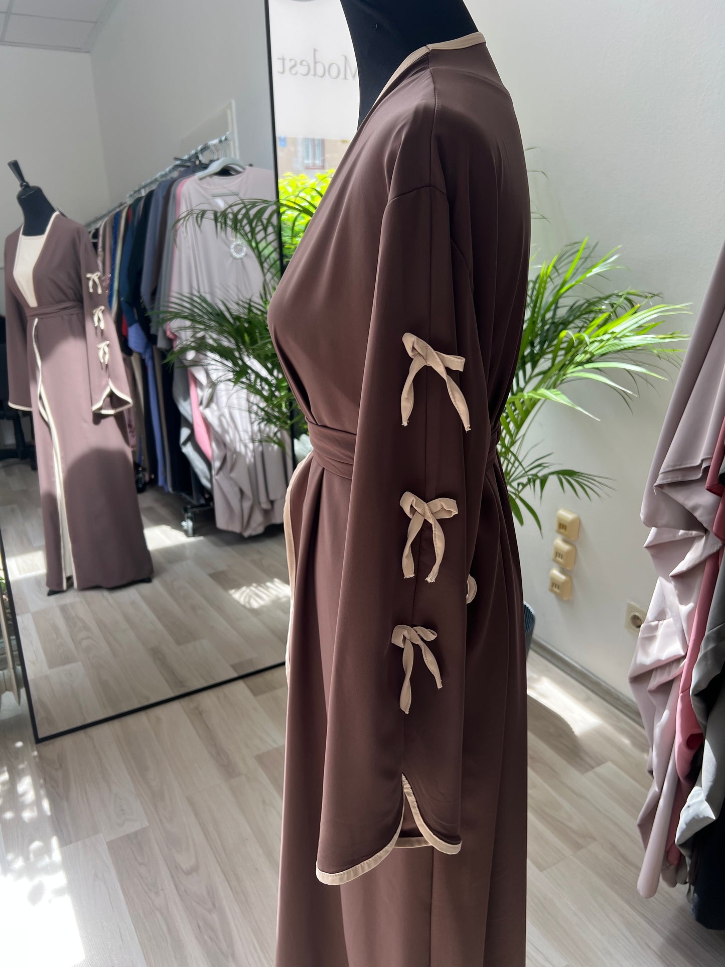 Braunes bodenlanges kleid mit beigen schleifen. Seitenfoto