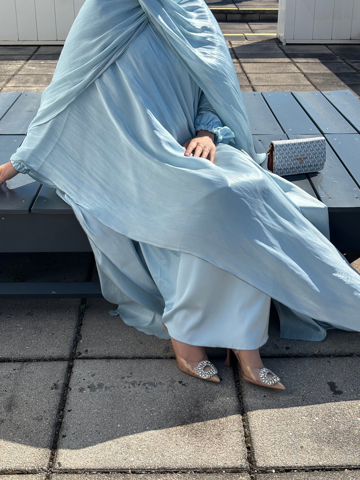 Abaya sherin - sitzend, detailansicht des stoffes in bewegung
