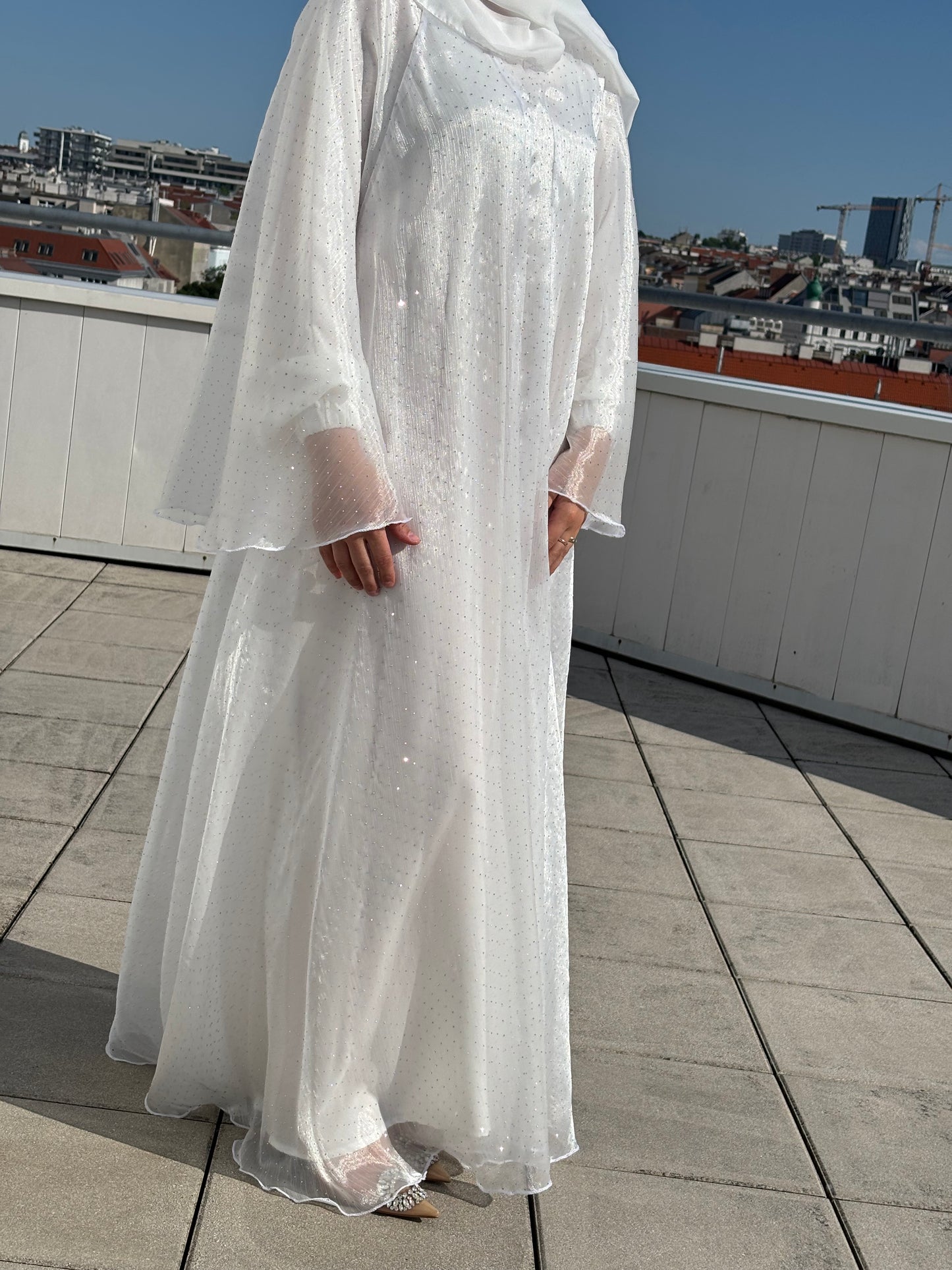 Detailaufnahme des Stoffes mit Lichtreflexionen – Ivory Glow Abaya in Bewegung