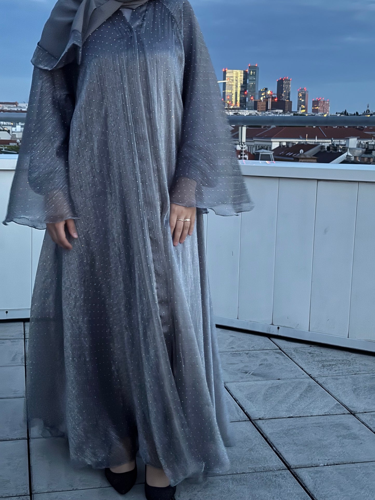 Abaya sheyla in moonlight silver - glitzerndes design bei dämmerung mit skyline im hintergrund