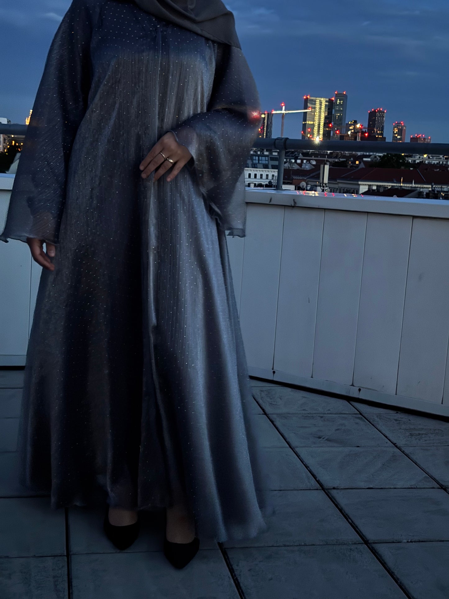 Detailansicht der abaya sheyla - silberner glitzerstoff mit flißender textur und transparenten ärmeln