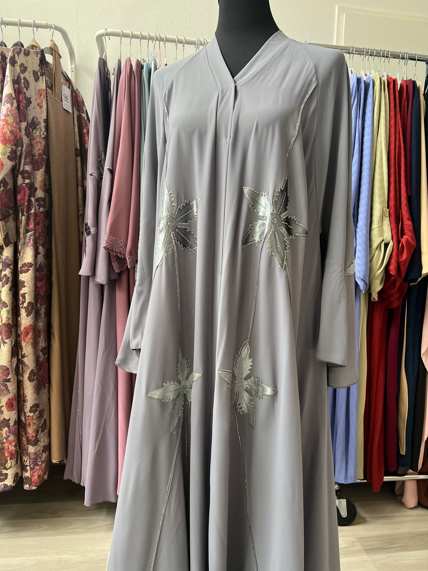 V-Ausschnitt und Frontpartie der grauen Kimono-Abaya mit Glitzerblättern