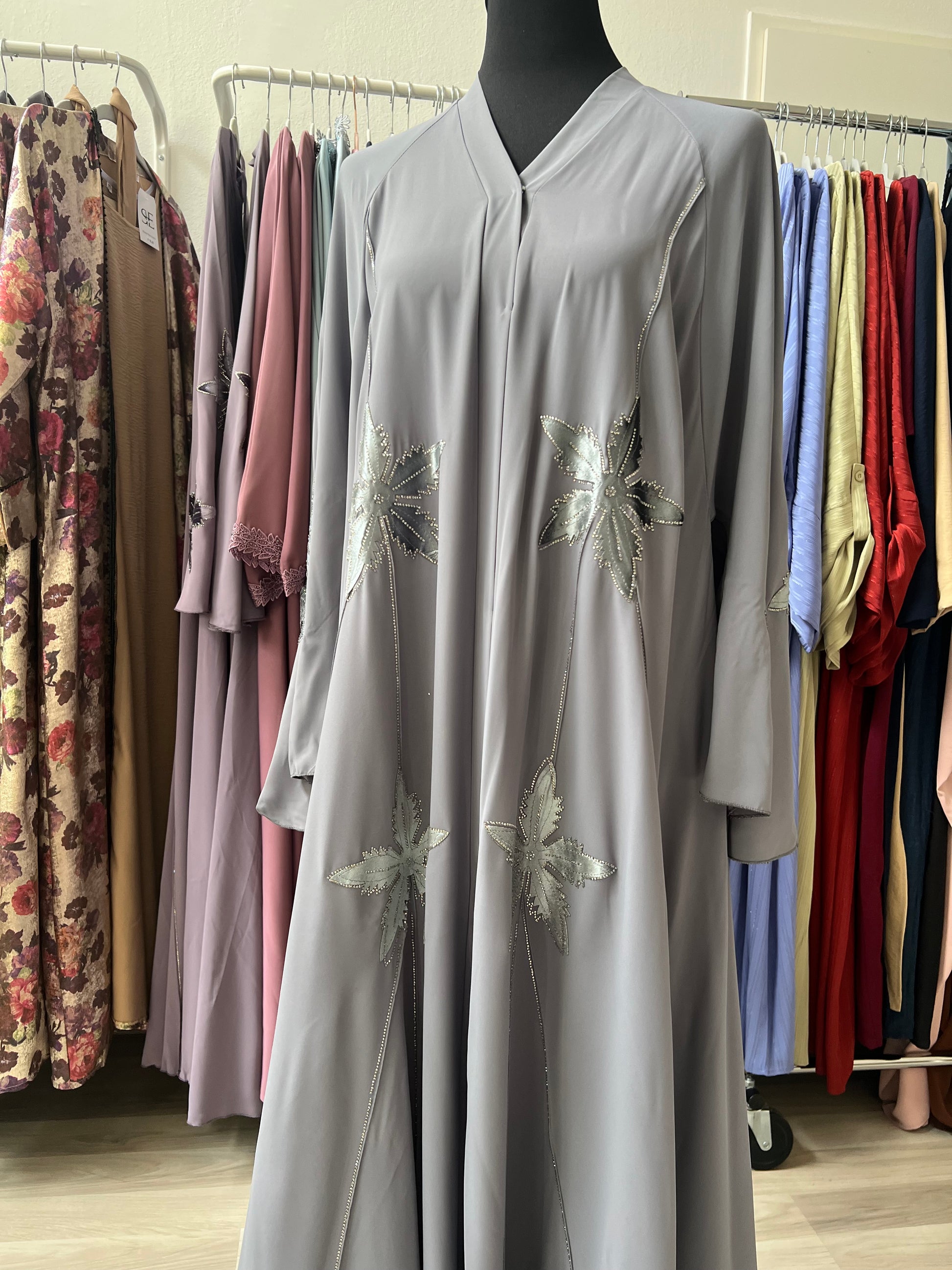 V-Ausschnitt und Frontpartie der grauen Kimono-Abaya mit Glitzerblättern