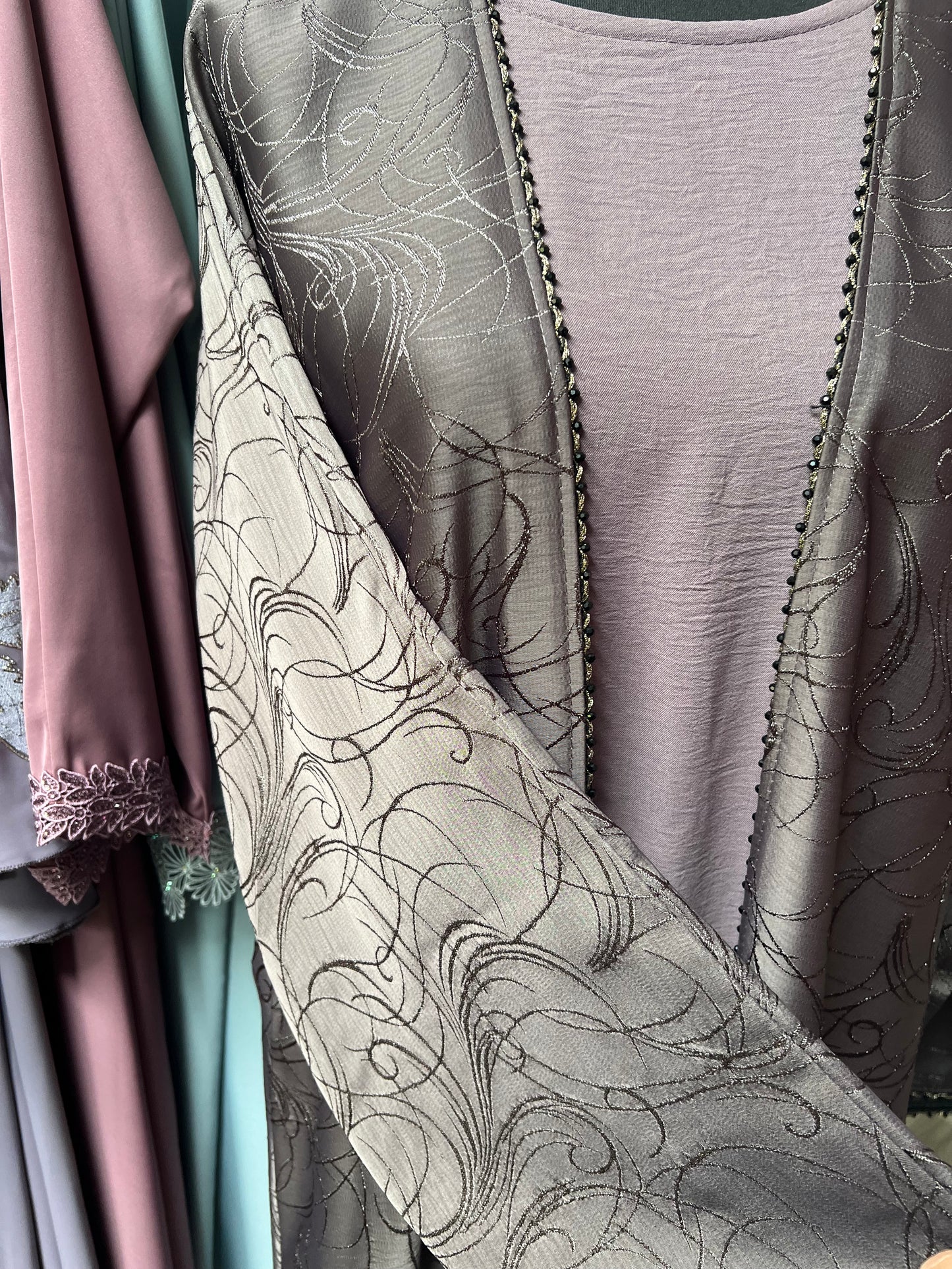 Detailaufnahme des Ärmels mit floraler Ton-in-Ton-Struktur und Perlensaum