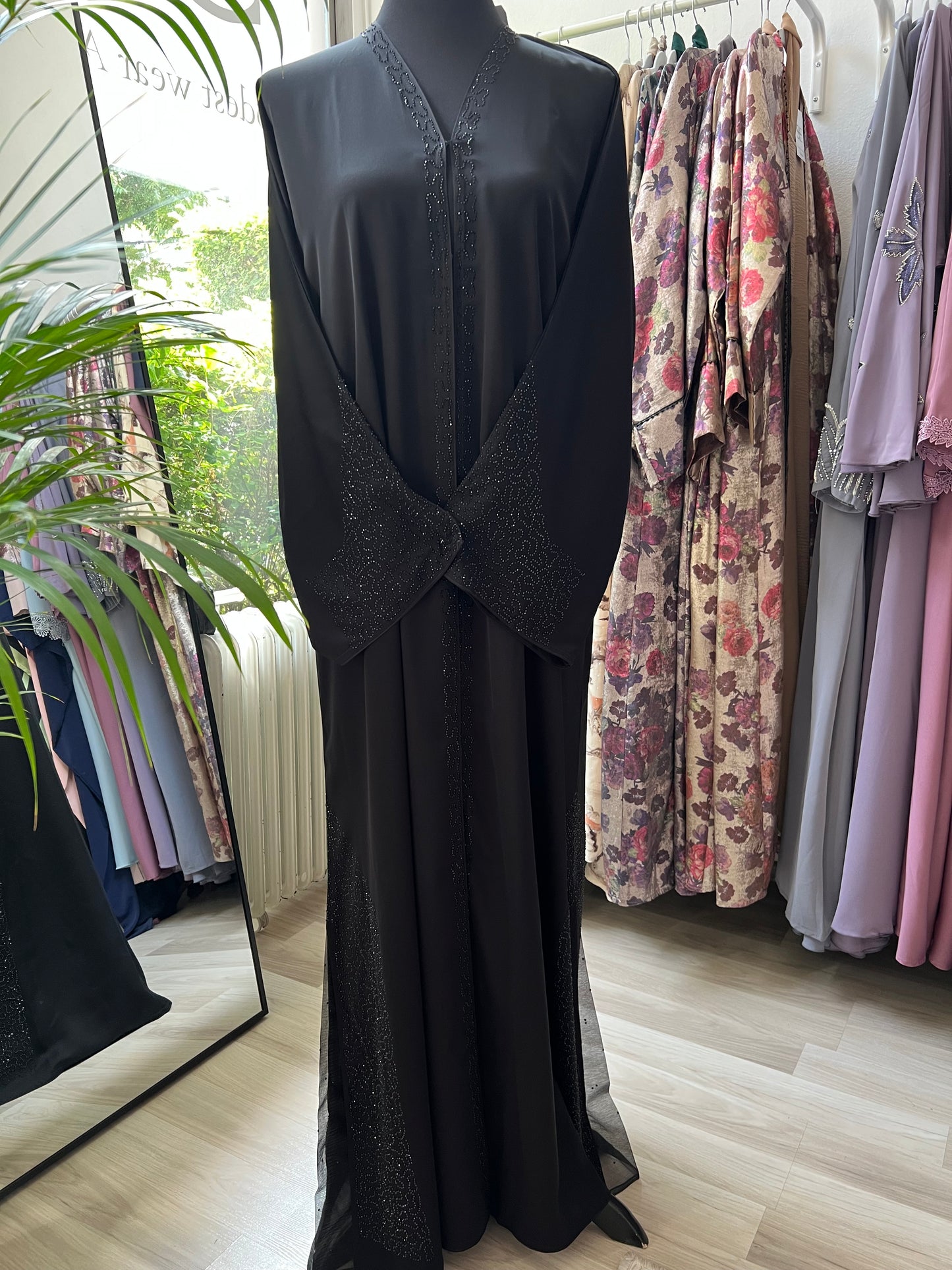 Nahaufnahme des seitlichen Chiffoneinsatzes mit funkelndem Steinchenmuster am Saum der Abaya.