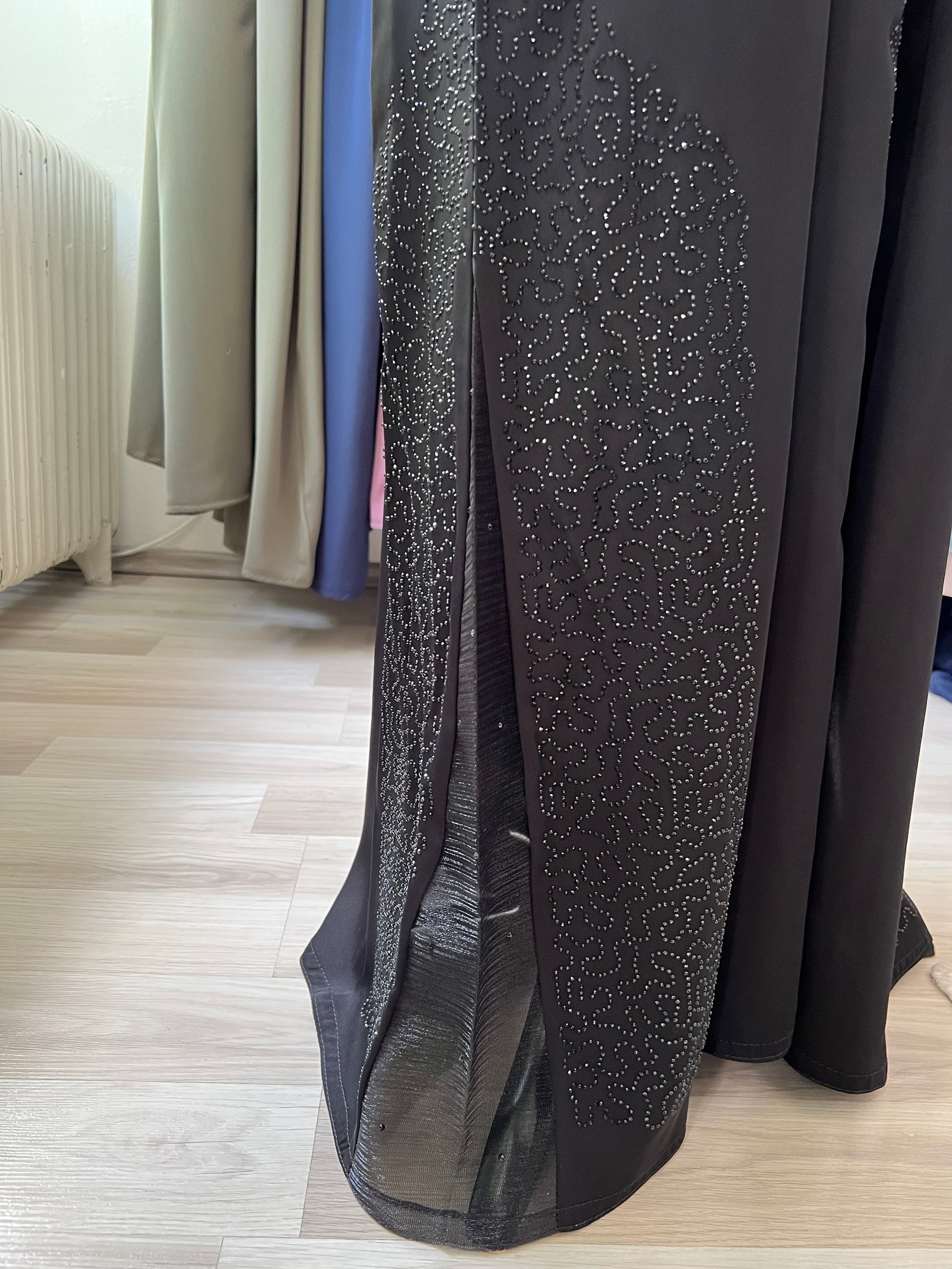 Nahaufnahme des seitlichen Chiffoneinsatzes mit funkelndem Steinchenmuster am Saum der Abaya.