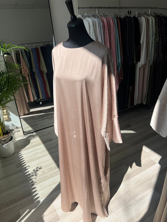 Frau trägt elegante abaya in beige mit schimmernden stoff - sheylin modest fashion wien