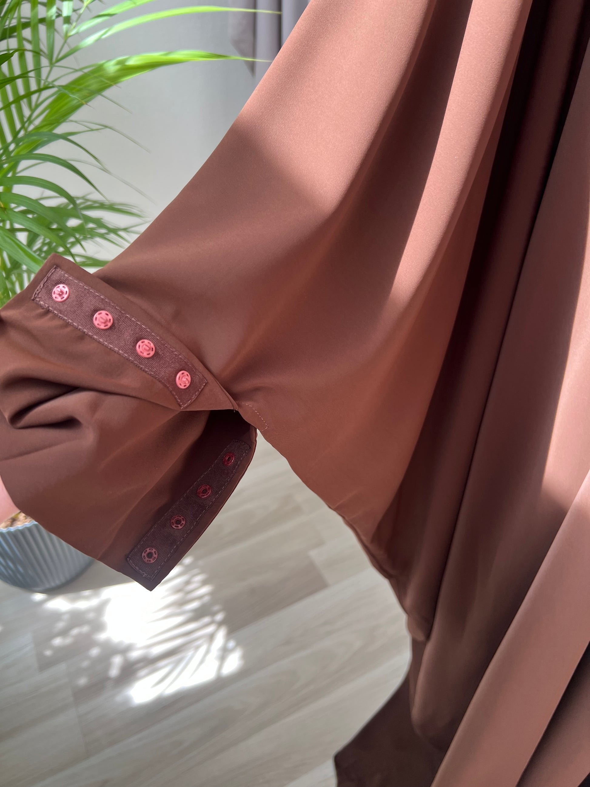 Versteckte knopfleise an den ärmeln braunes kleid