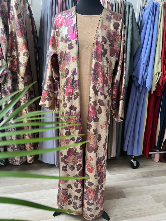 Abaya Rania in Blossom Gold auf einer Schneiderpuppe, mit floralem Jacquard-Stoff und dezentem Perlbesatz – aufgenommen im Sheylin Showroom.“