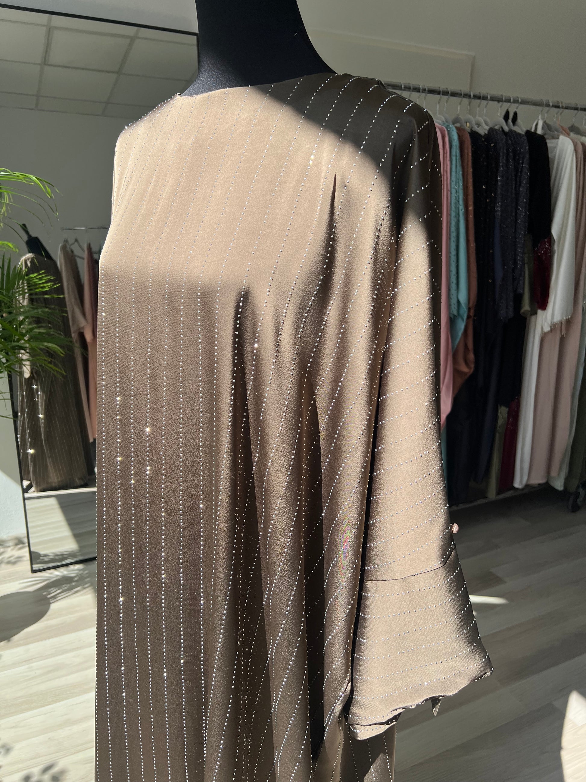 Frau trägt Sommerkleid mit feinen Glitzerlinien. Abaya Wien