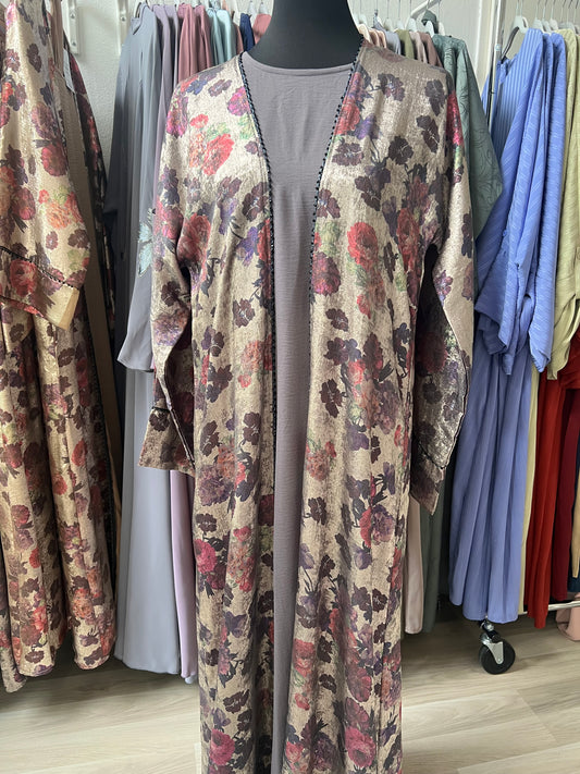 Florale Jacquard-Abaya in Beigetönen mit Rosenmuster, getragen über grauem Unterkleid, fotografiert im Tageslicht