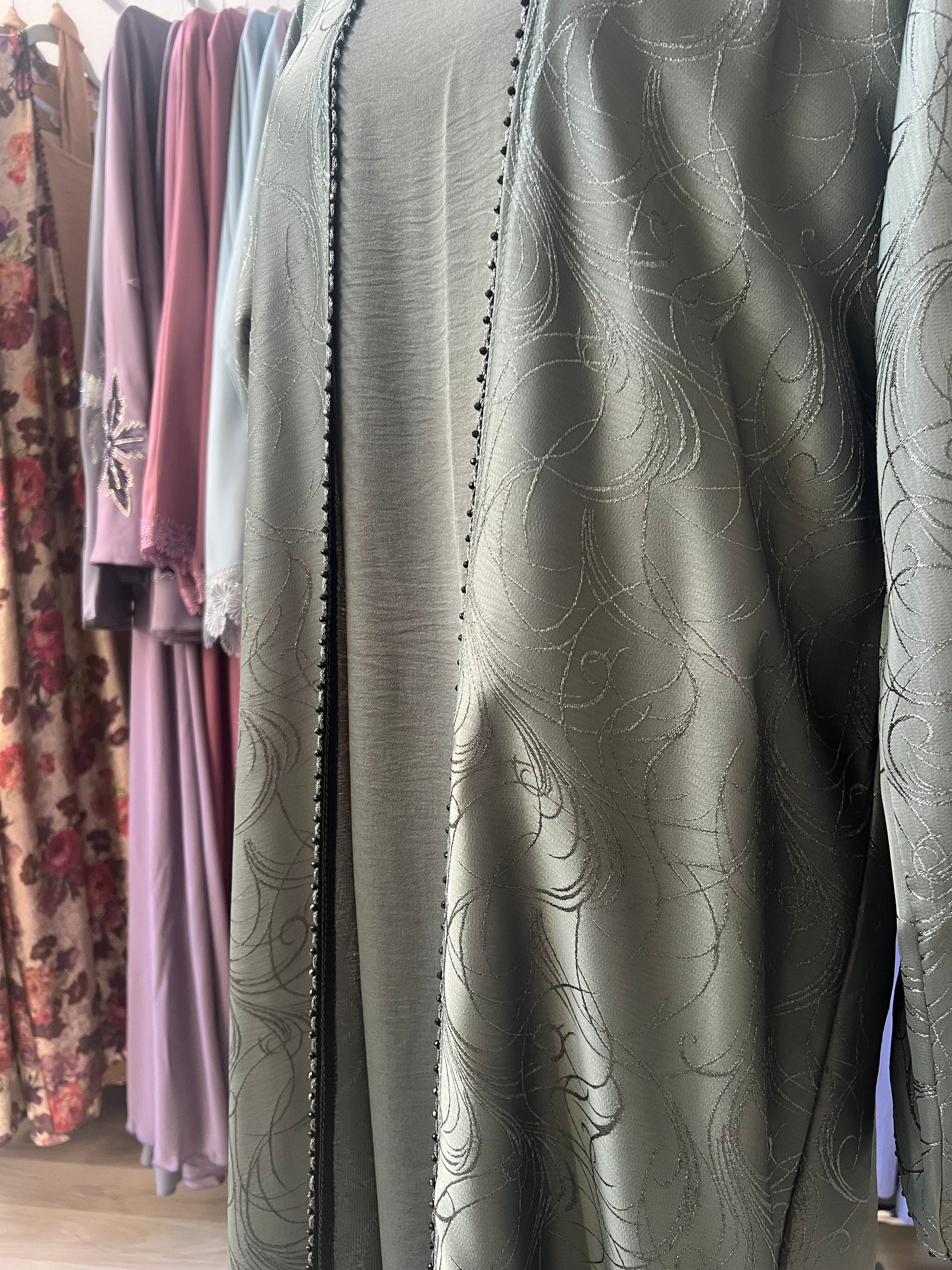„Abaya Nura in Olivegrün – Detailaufnahme der Ärmel mit feiner Struktur und glänzendem Stoff