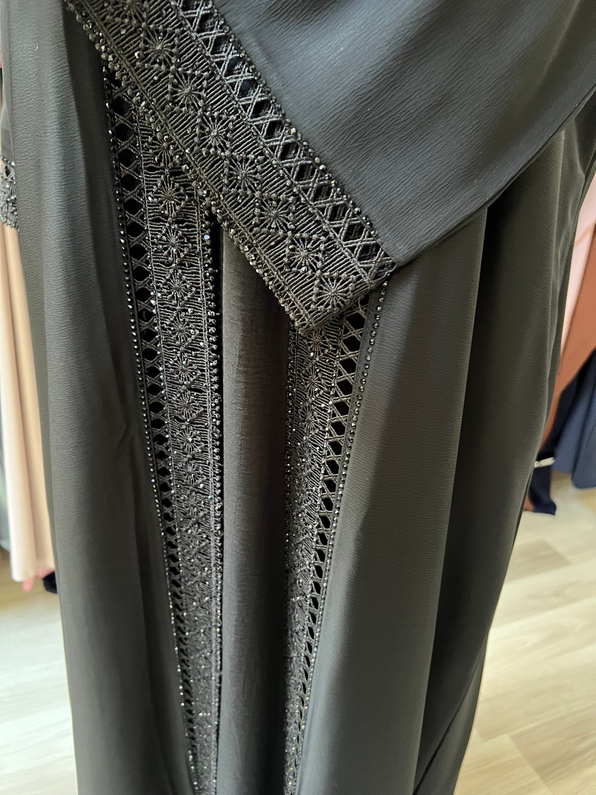 Nahaufnahme des verzierten Vorderteils der Abaya mit edler Glanzverarbeitung.