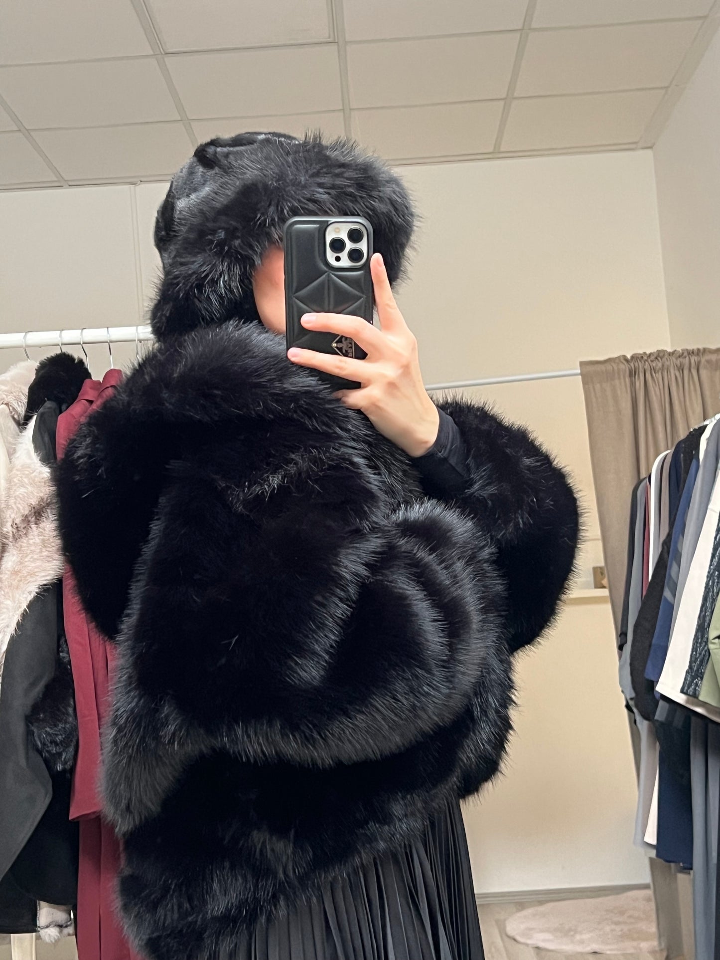 Seitliche Ansicht schwarze Kunstfelljacke mit großer Kapuze, stylische und warme Winterjacke für Modest Outfits
