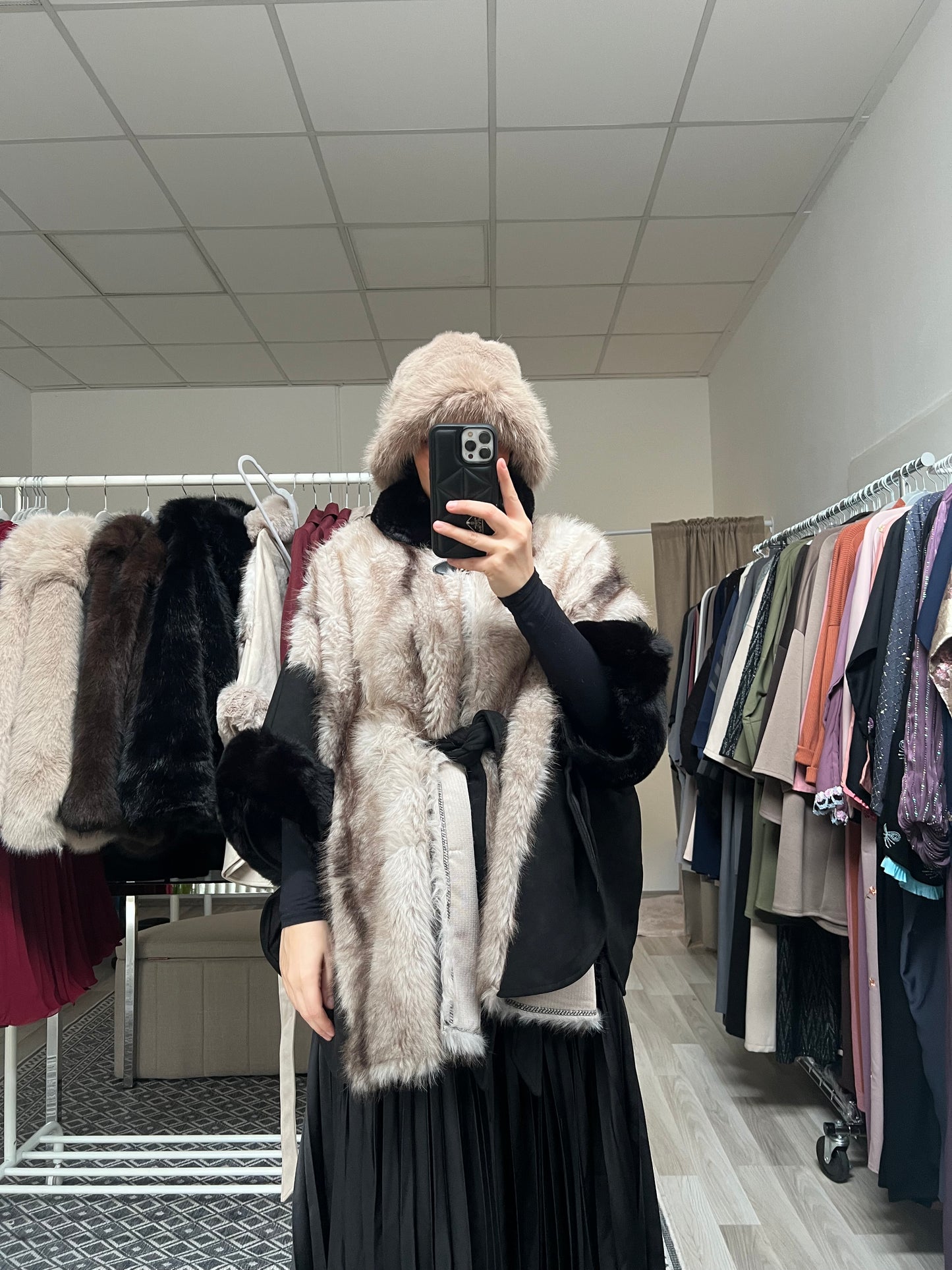 Schwarzes Kunstfell Cape über plissiertem Rock getragen, luxuriöses Modest Fashion Cape für Herbst und Winter, Sheylin Wien
