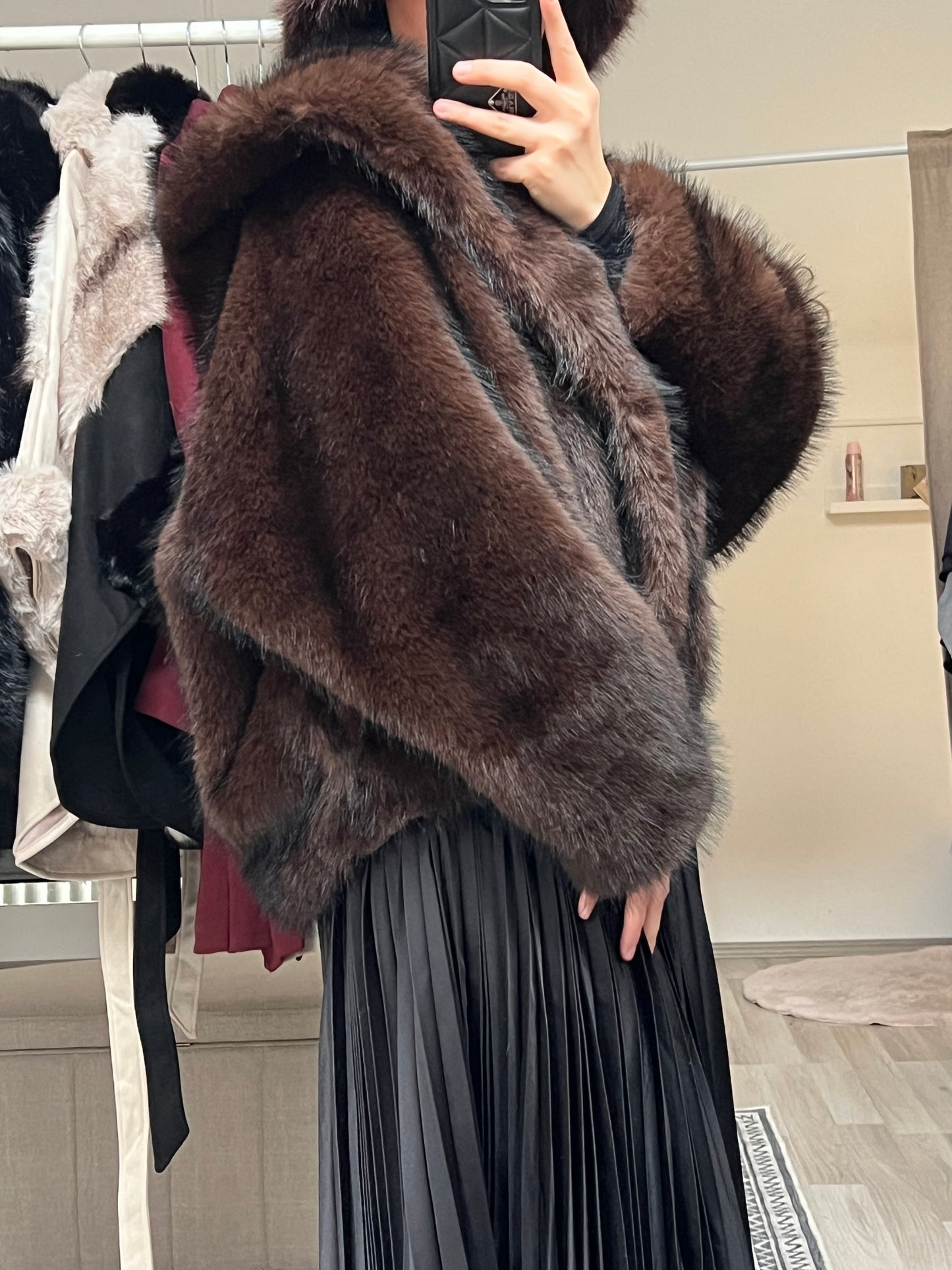 Detailaufnahme der dunkelbraunen Felljacke mit breiten Ärmeln aus flauschigem Kunstfell.