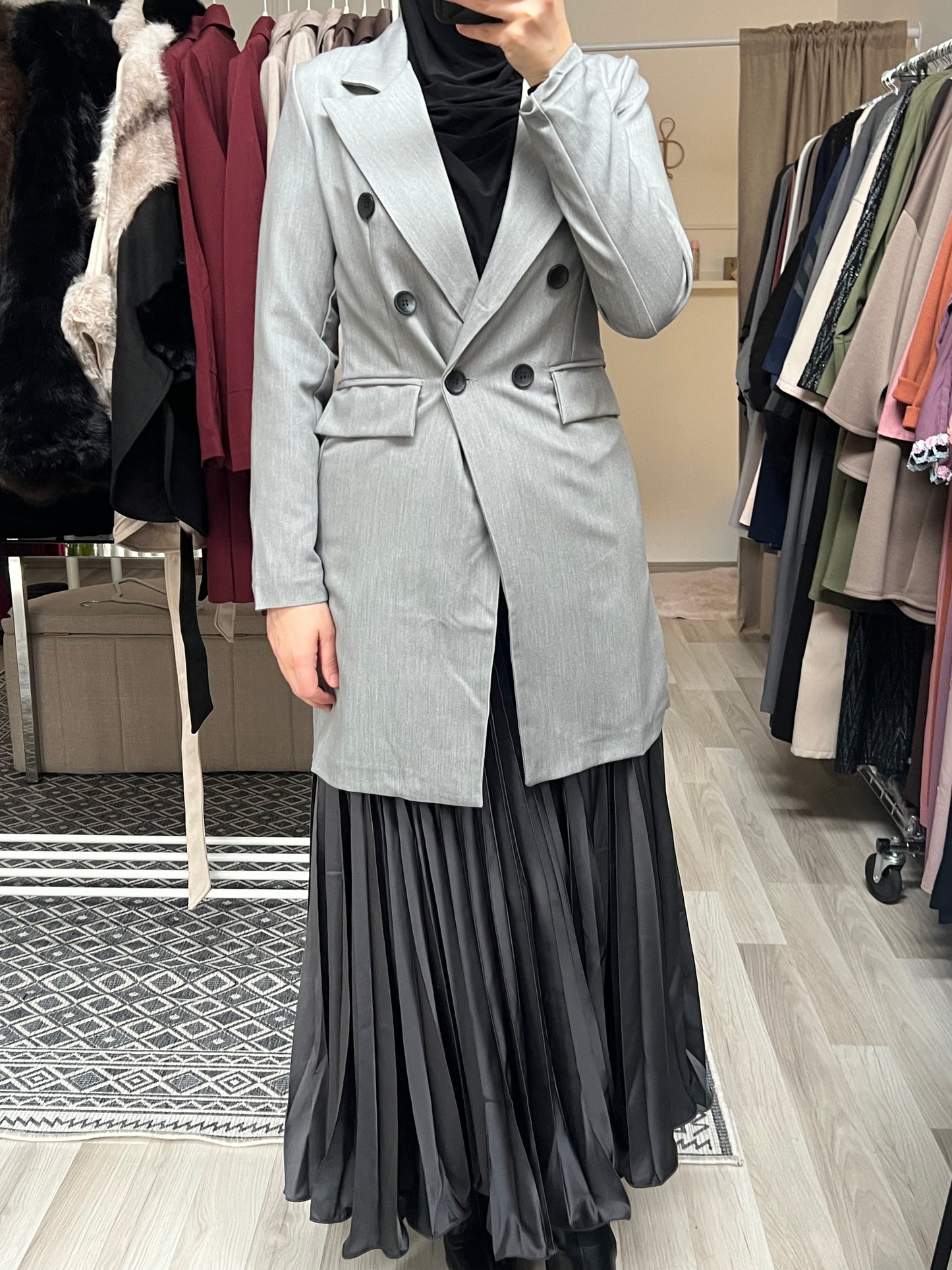 Grauer Longblazer für Damen im modischen Schnitt, doppelte Knopfleiste, kombiniert mit schwarzem Plisseerock – Modest Fashion Wien
