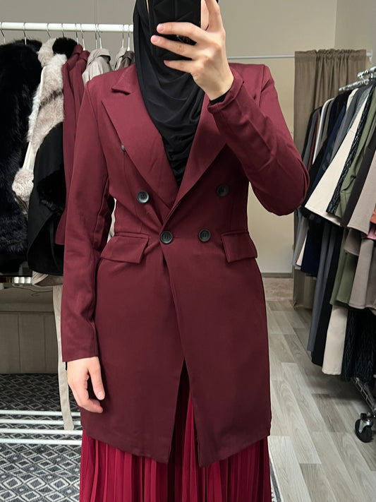 Bordeauxfarbener Longblazer für Damen in modester Passform mit doppelter Knopfleiste, getragen mit schwarzem Hijab und Plisseerock