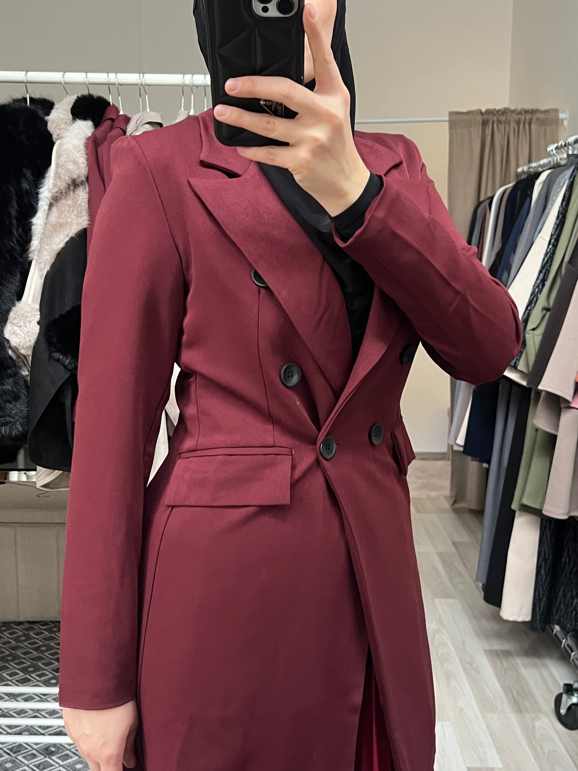 Detailaufnahme des bordeauxfarbenen Longblazers mit doppelreihiger Knopfleiste und klassischem Reverskragen