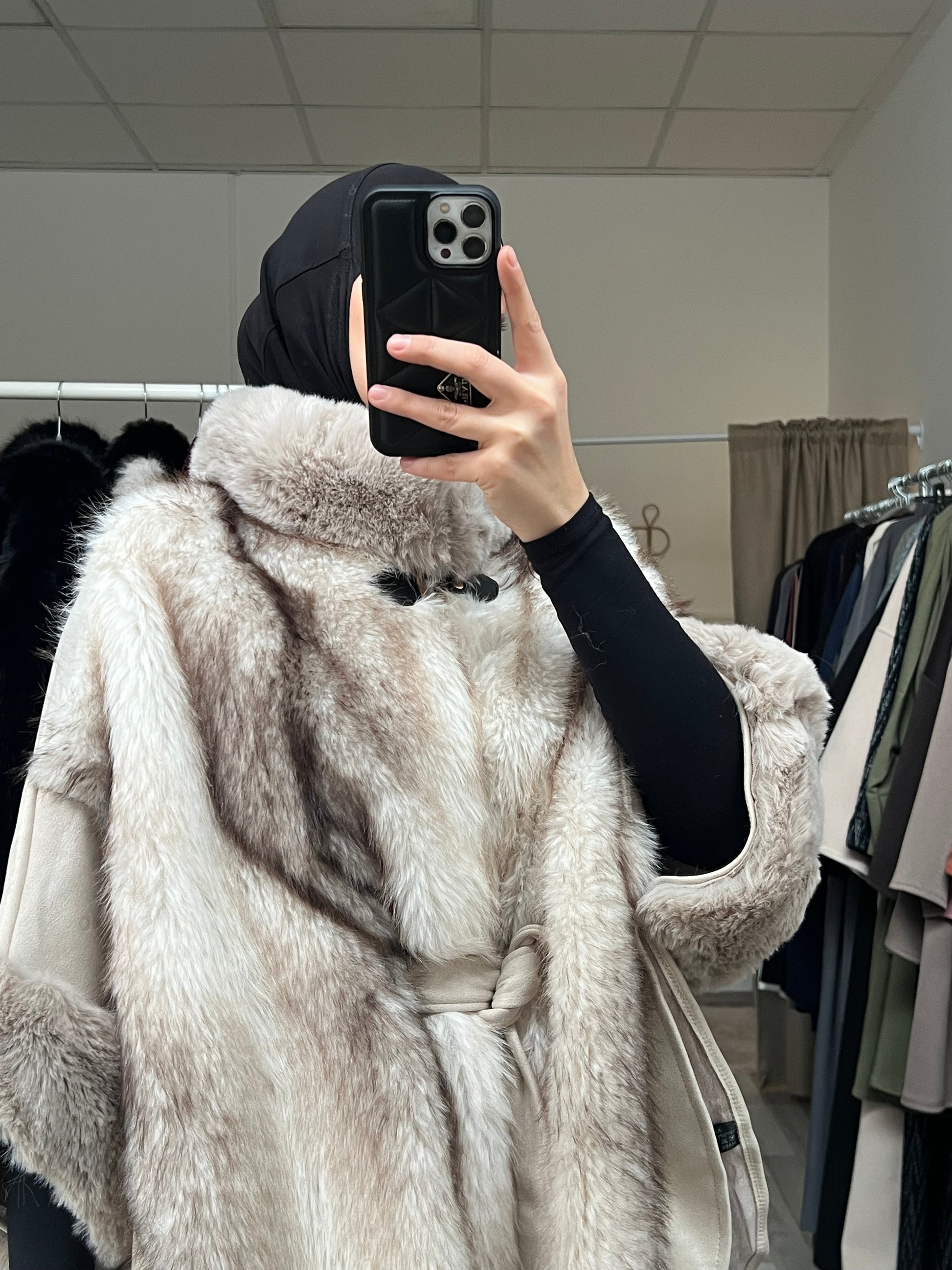 Beiger Cape aus flauschigem Kunstfell mit hohem Kragen und Gürtel, detailreiche Verarbeitung in neutralem Beigeton