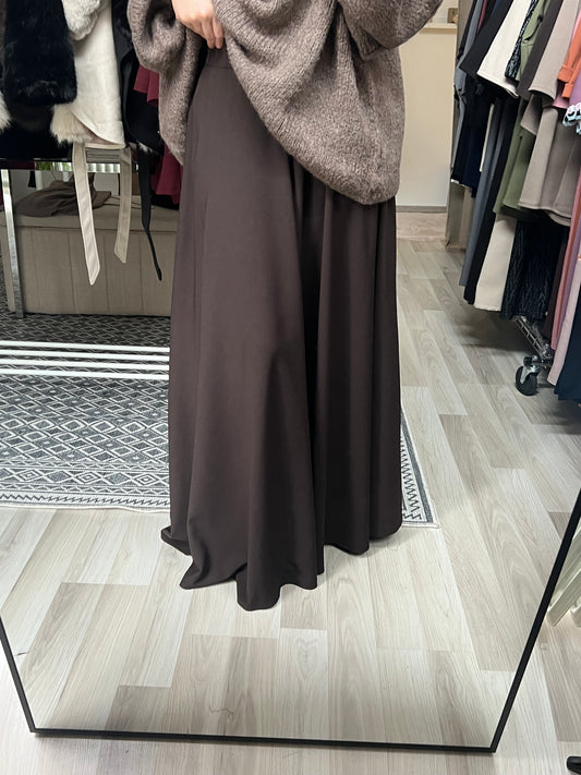 Maxirock in Dunkelbraun mit fließendem Stoff und bodenlanger Passform, kombiniert mit Oversize-Strickpullover im Showroom in Wien