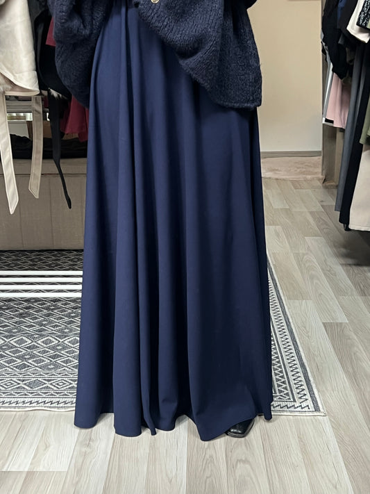 Dunkelblauer Maxirock mit fließendem Fall, bodenlang geschnitten, kombiniert mit Oversize-Strickpullover – elegante Modest Fashion