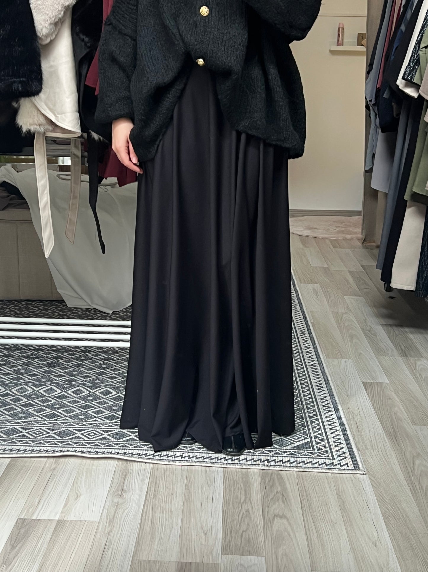Eleganter schwarzer Maxirock mit fließendem Fall und elastischem Bund, kombiniert mit Strickjacke – Modest Fashion Maxirock für Hijabis, erhältlich bei Sheylin Wien
