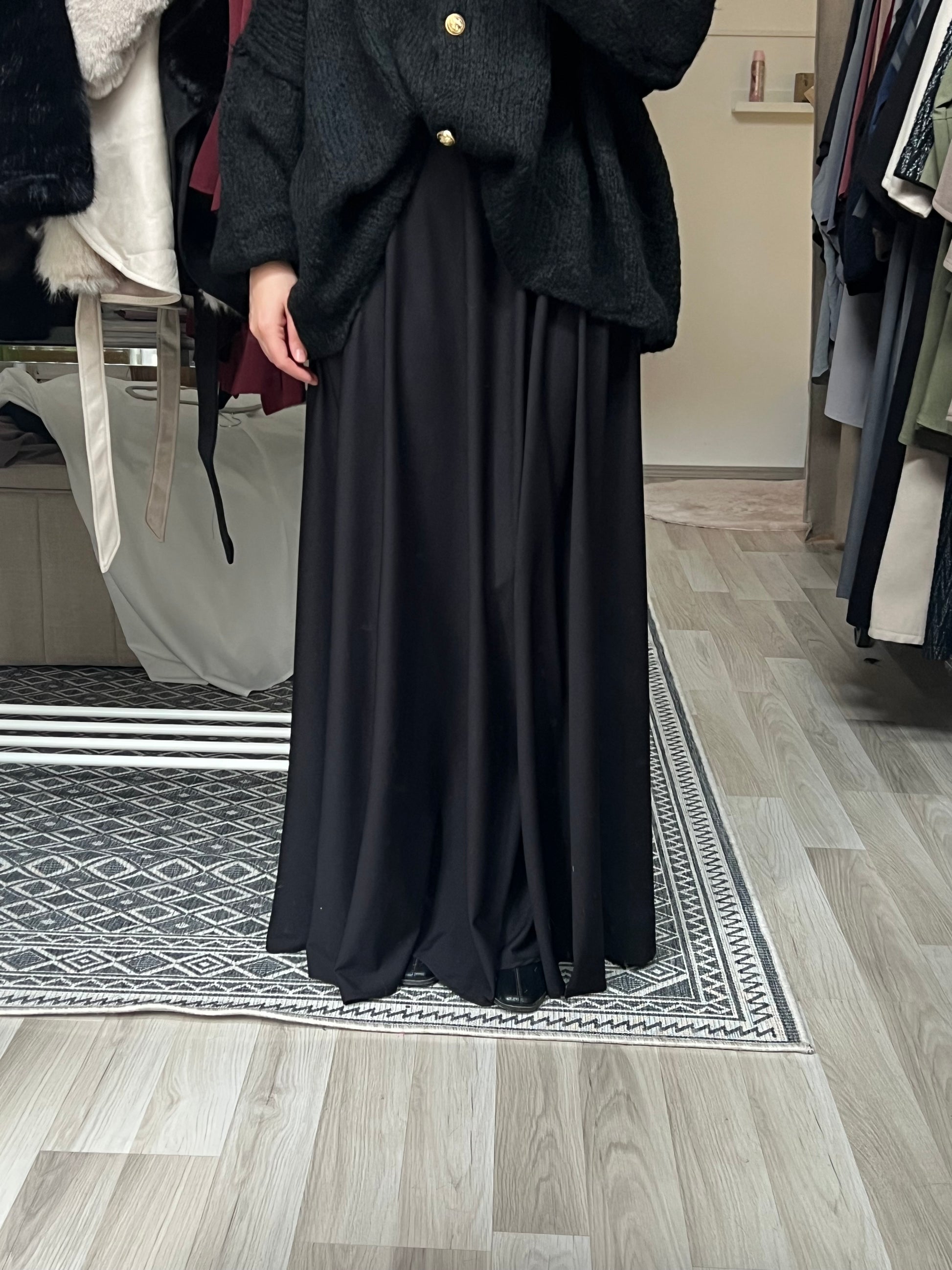 Eleganter schwarzer Maxirock mit fließendem Fall und elastischem Bund, kombiniert mit Strickjacke – Modest Fashion Maxirock für Hijabis, erhältlich bei Sheylin Wien
