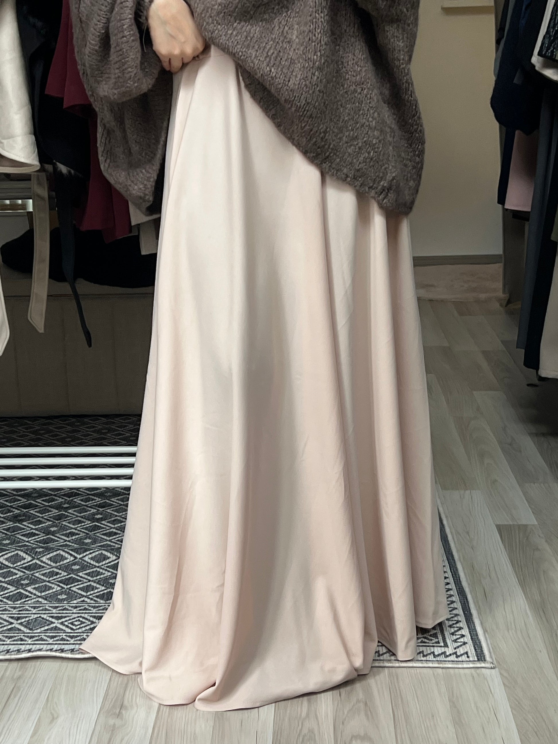 Fließender Maxirock in softem Peach-Ton mit elegantem Fall, kombiniert mit Oversize-Strickpullover – moderner Modest Fashion Look von Sheylin Wien